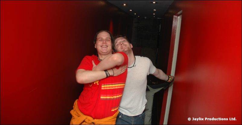 Two people embracing in a red doorway, one in a red top