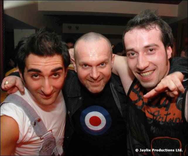 Three people pose close together, the middle one in a target logo t-shirt, the others pointing at the camera