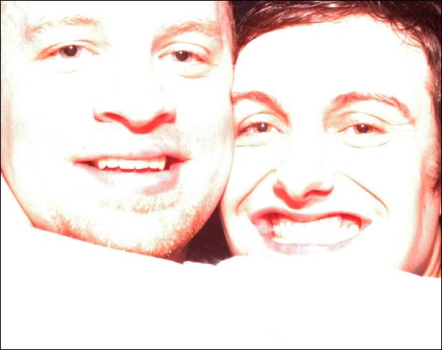 Close-up of two smiling people's faces, heavily overexposed