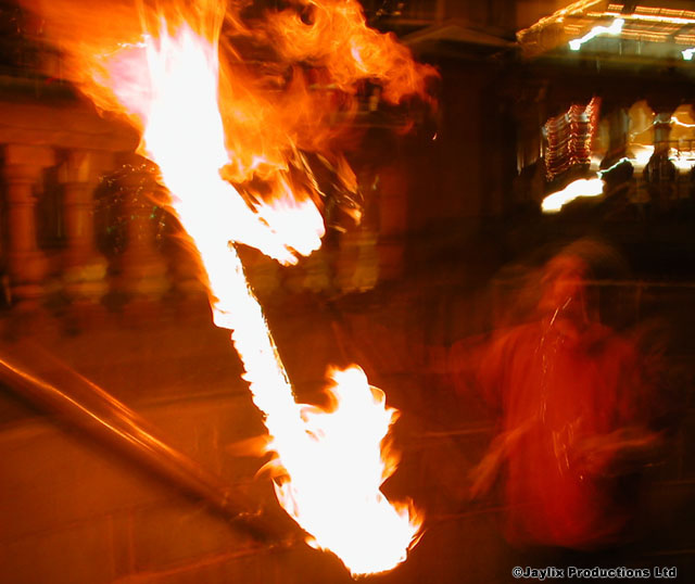 A long flame in a dark room, blurred with motion