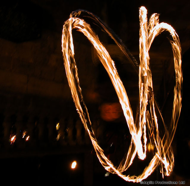 Looped trails of fire light against a dark night sky