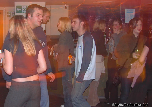 People stand and dance in a busy bar