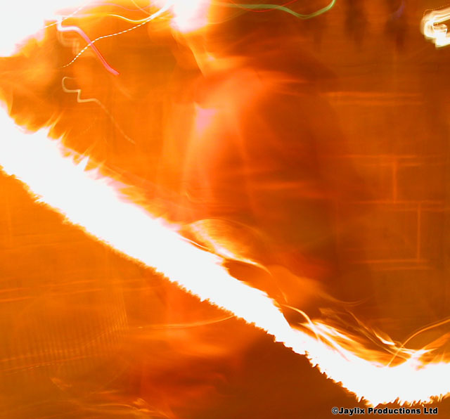 A bright streak of white light across a blurred orange scene