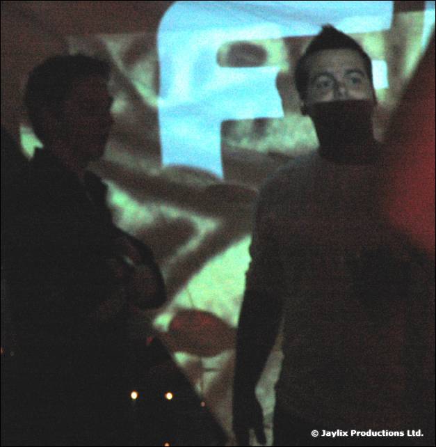 Two silhouetted people stand in front of a projected FIRE logo