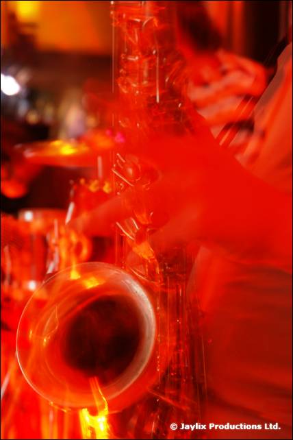 A saxophone bell in a blur of orange and red light