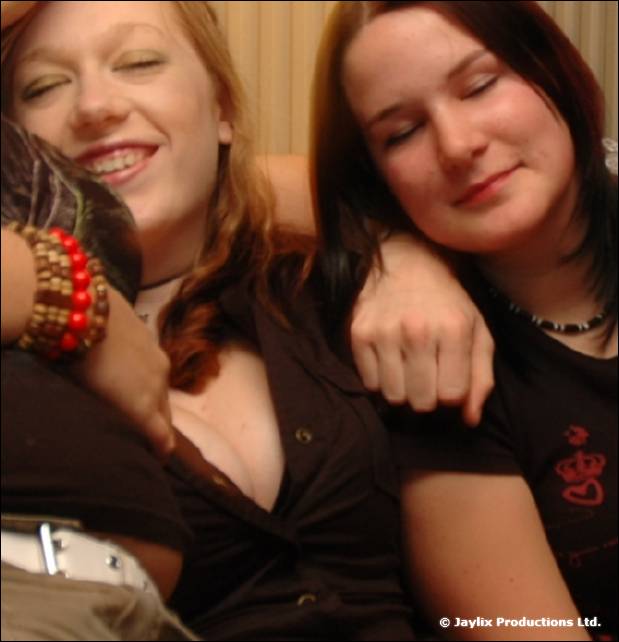 Two women lean their heads together with their eyes closed