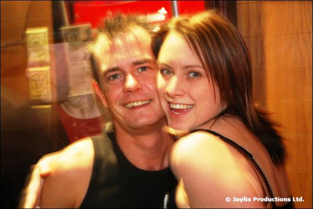 A smiling man and woman lean their heads together