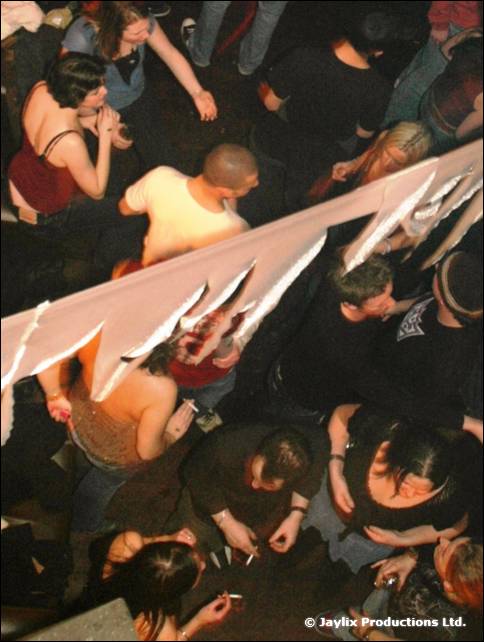 Overhead view of a crowd on a dance floor beneath a white streamer