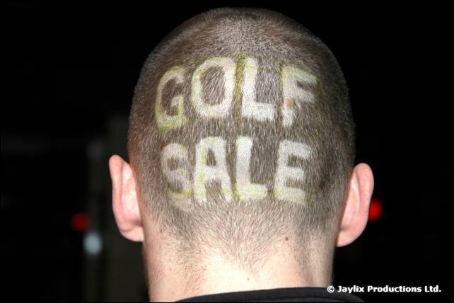 The back of a shaved head with the words Golf Sale cut into the hair