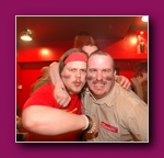 A small framed picture of two people in red smiling together, on a purple background