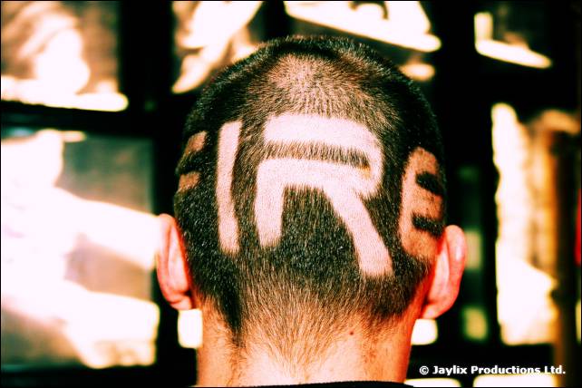 The back of a shaved head with the word FIRE cut into the hair, against a bright background