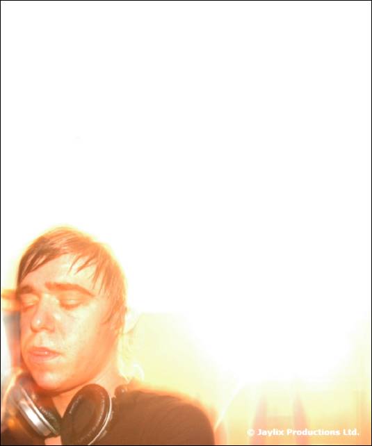 A person with eyes closed and headphones round the neck in a washed out white background