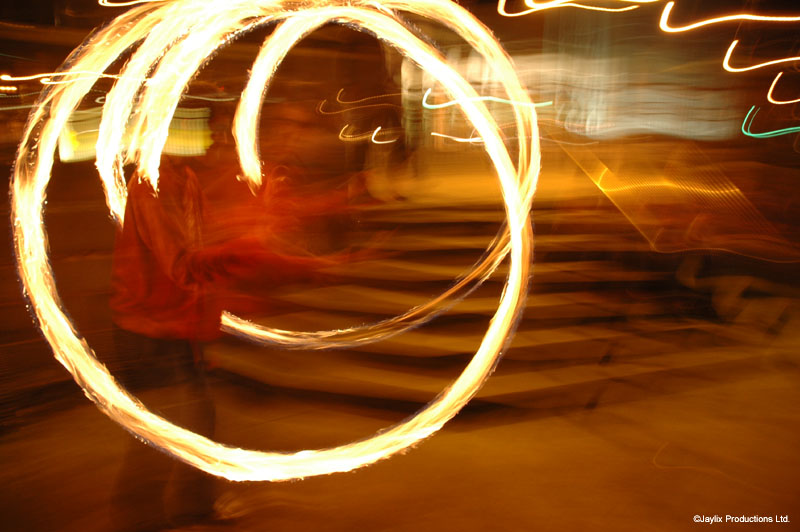 A large circle of fire trail in front of stone steps at night