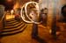 Tiny thumbnail of a fire spinner at night in a lit stone doorway