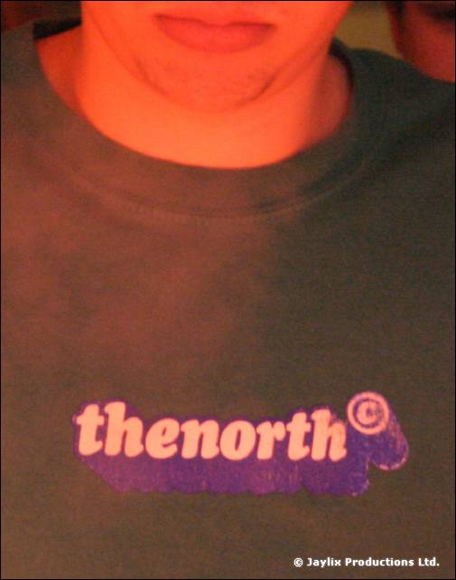 Close crop of a person's chin and a dark T-shirt printed with the word thenorth