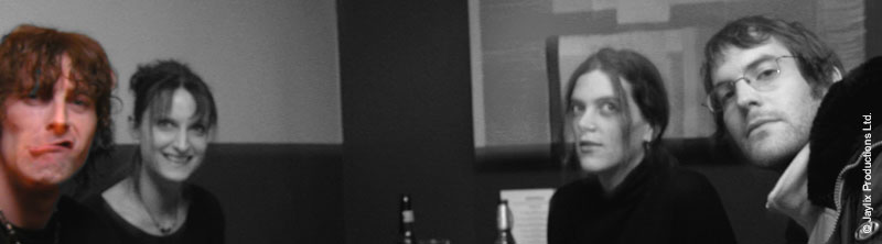 Black and white wide crop of four people's faces looking at the camera
