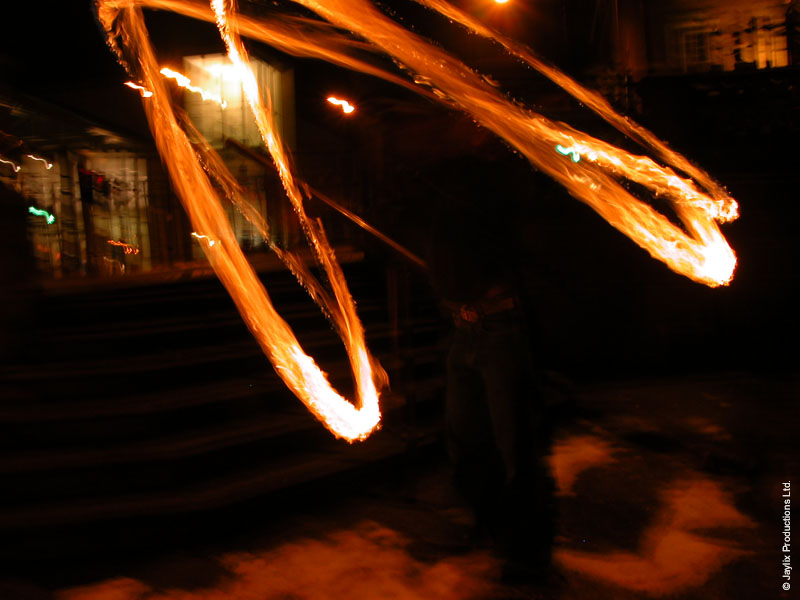 Long curved streaks of fire in the dark, with steps just visible behind
