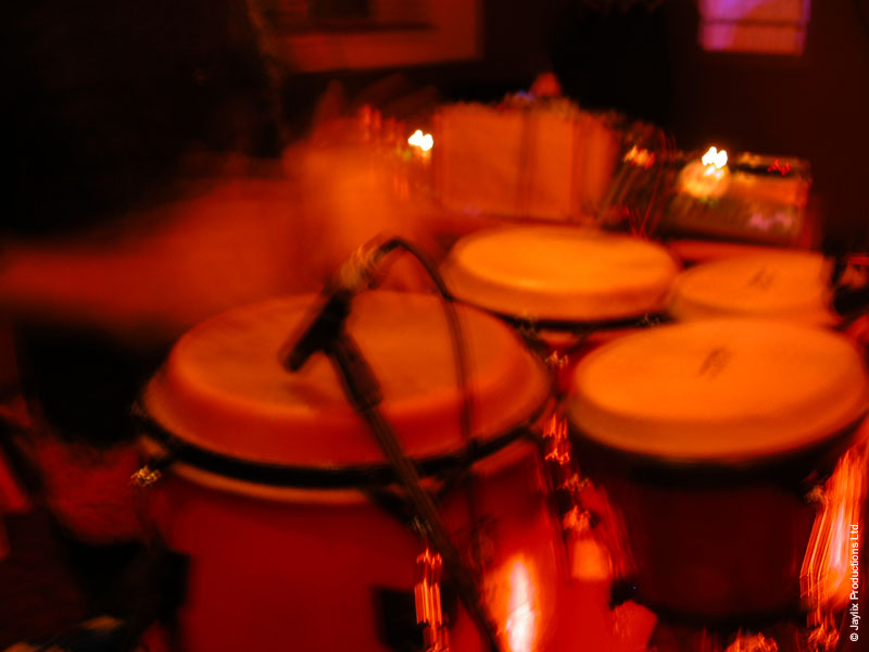 Close-up of red congas with a microphone, blurred and lit orange
