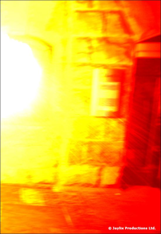 Very overexposed orange and yellow image of fire beside a stone wall