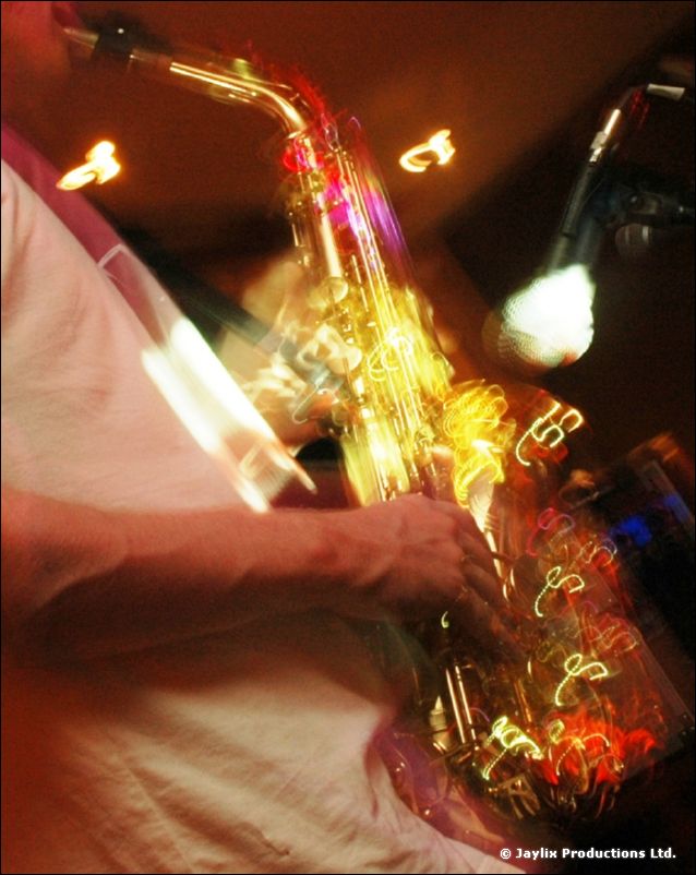 Close-up of a saxophone and a microphone, blurred with movement