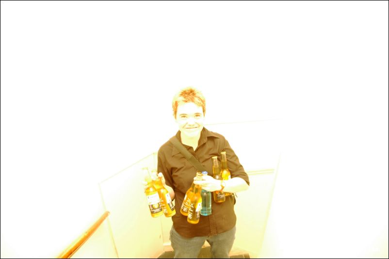 A person holds several bottles in an overexposed, nearly white photo