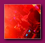 Small framed thumbnail of a DJ booth lit in bright red