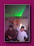 Small framed thumbnail of DJs at decks with a green laser beam above
