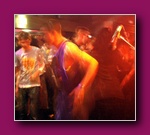 Small thumbnail of blurred people dancing in a dark, red-lit room