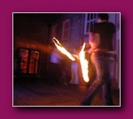 Small thumbnail of a dark stage with a blurred figure and trails of fire