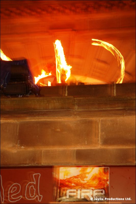 Flames and a glowing fire prop on a stone ledge above a "FIRE" sign