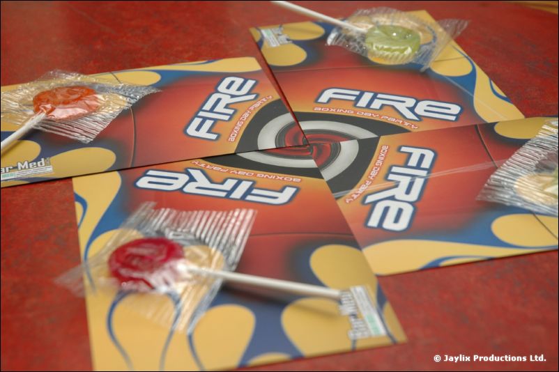 Several FIRE flyers with lollipops in wrappers lie on a red table