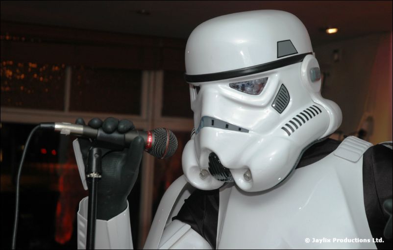 A stormtrooper costume head and shoulders beside a microphone on a stand