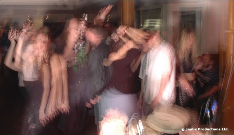 Dancers blurred by motion in a dim bar