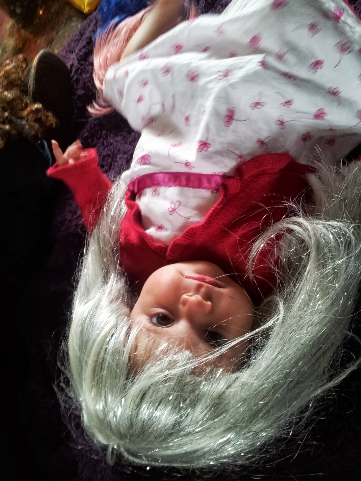 Upside down baby doll in a red top with a silver wig