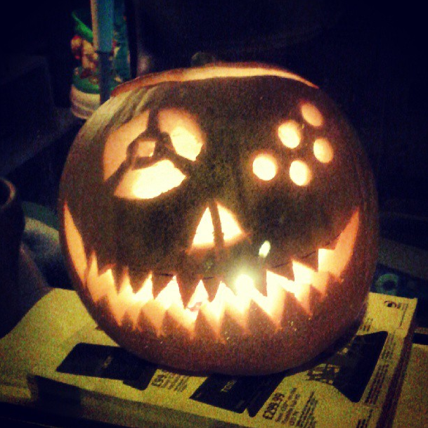 Carved pumpkin with a lit candle, glowing in the dark