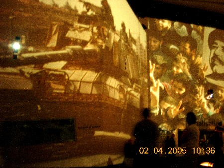 Dim projected images on a wall in a museum space, with date stamp 02.04.2005