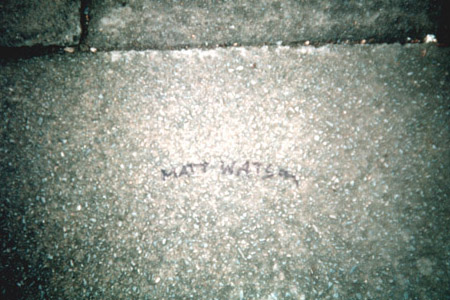 Stone or tarmac surface with the handwritten words Matt Watson