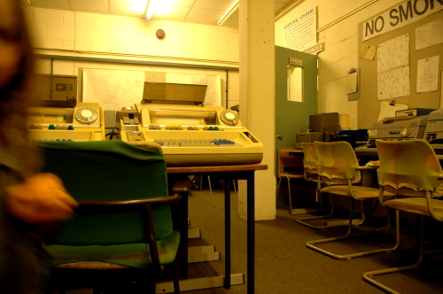 Office in a bunker with old teleprinters, desks and chairs, and a No Smoking sign