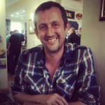 Smiling man in a checked shirt indoors