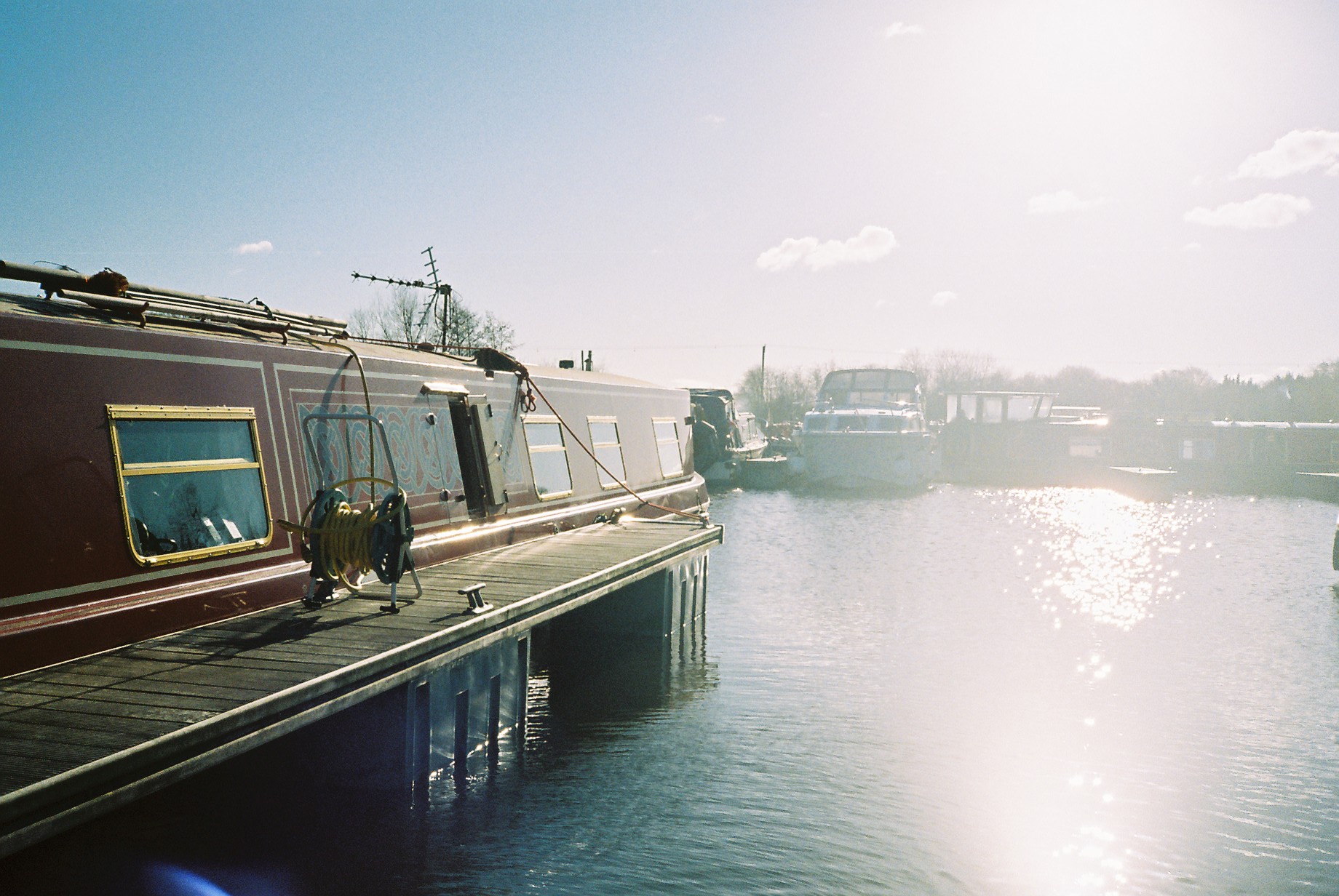 Narrowboat moored at a canal bank in bright sunlight