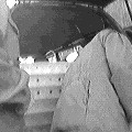 A collection of trays in the back of a van with a person unloading, black-and-white