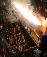 Sparks or flares shooting across a busy nightclub balcony